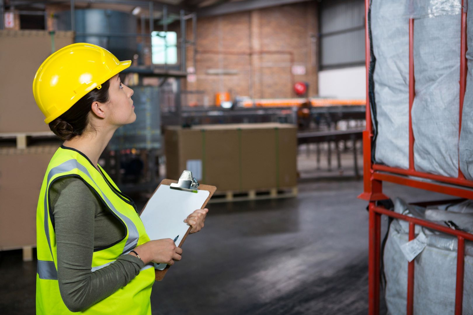confident-female-worker-examining-products-warehouse